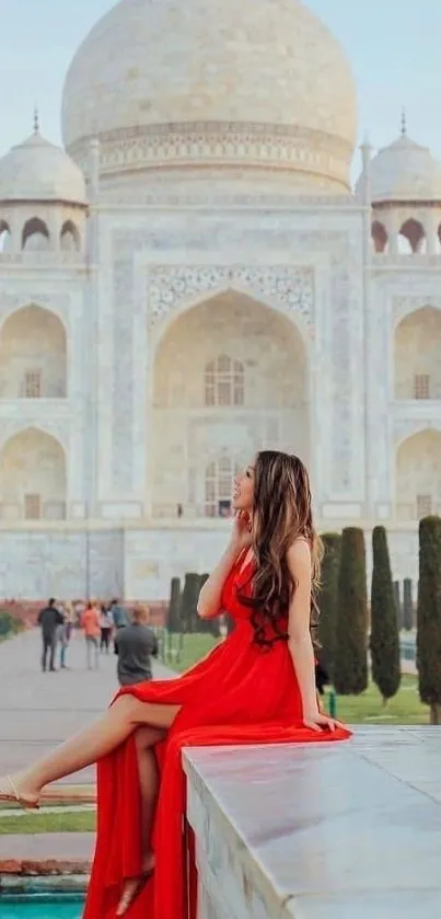 Woman in red dress at the majestic Taj Mahal, showcasing elegance and architectural beauty.