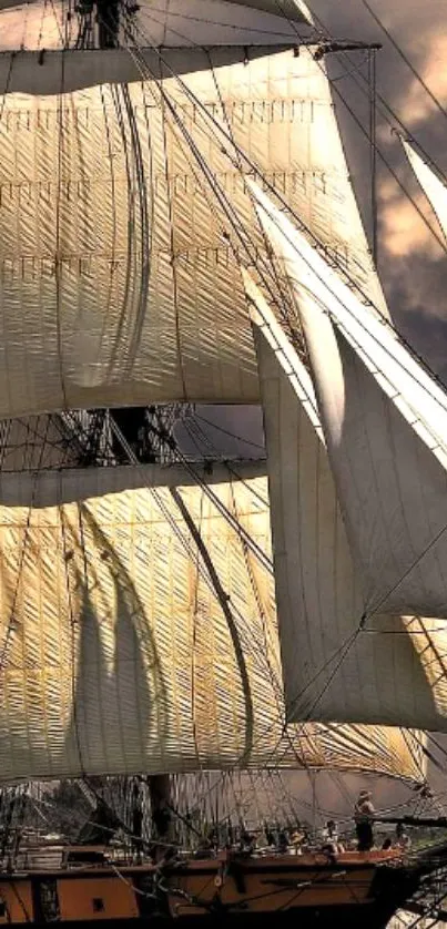 Majestic tall ship with beige sails and dramatic sky.