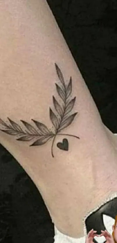 Stylish tattoo design with leaf and heart on leg.