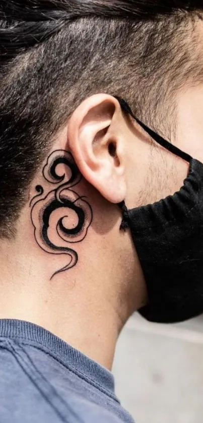 Side view of person with elegant black tattoo behind ear on skin.