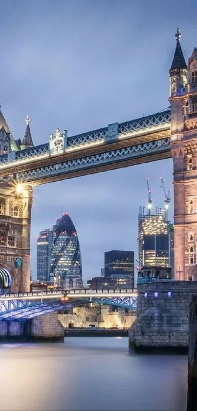 Tower Bridge illuminated at dusk with city skyline in the background.