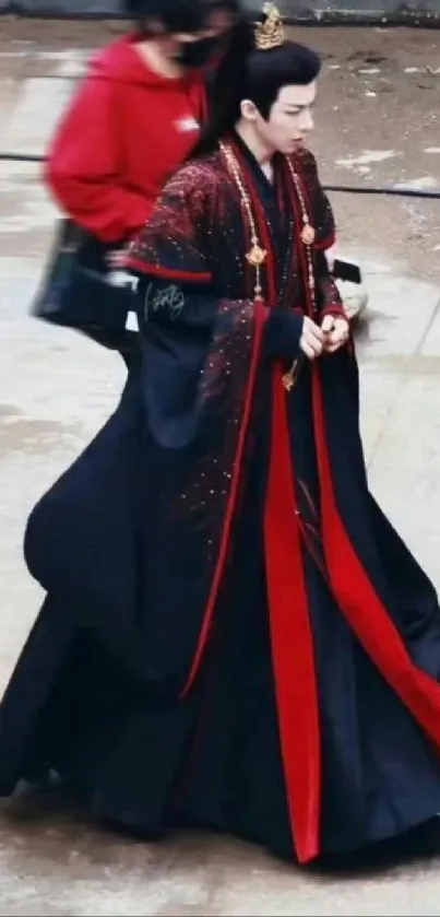 Man in elegant traditional attire with a rich black and red robe.