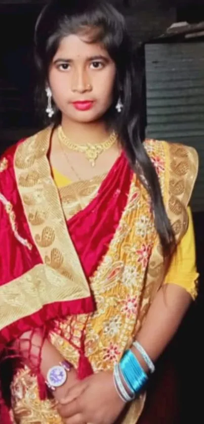 Portrait of a woman in vibrant red and gold traditional attire.