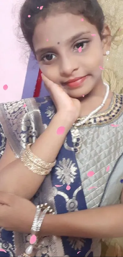 Young girl in traditional attire posing elegantly with jewelry.