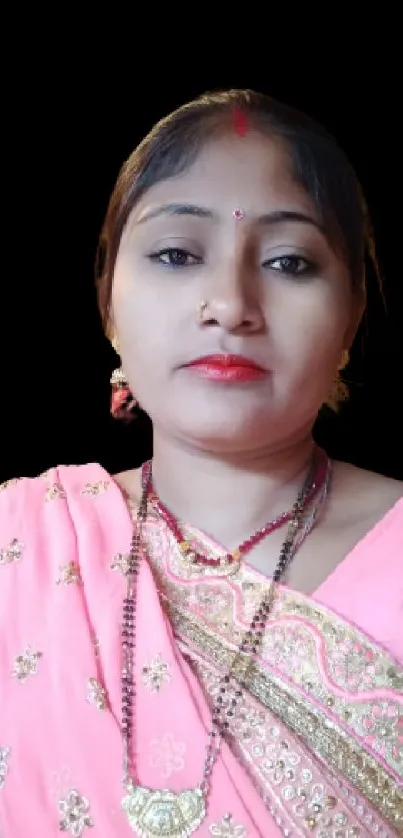 Woman in traditional Indian sari with pink embroidery.