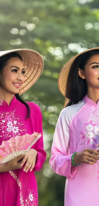 Two women in pink Vietnamese Ao Dai in nature.