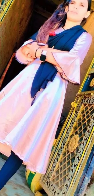 Woman in traditional attire at a decorative doorway.