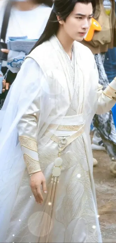 Young man in elegant white and gold traditional costume.