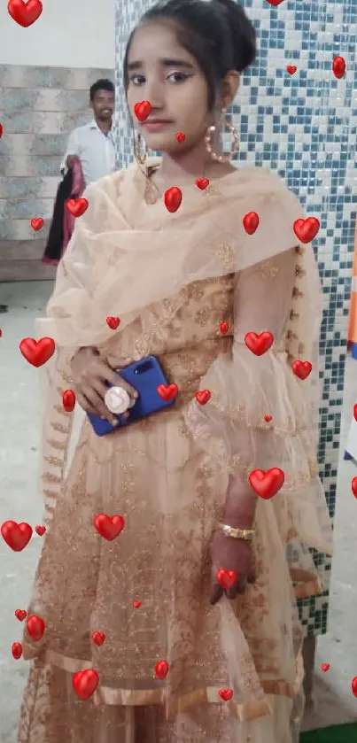 A person in an elegant, beige traditional dress holding a phone.