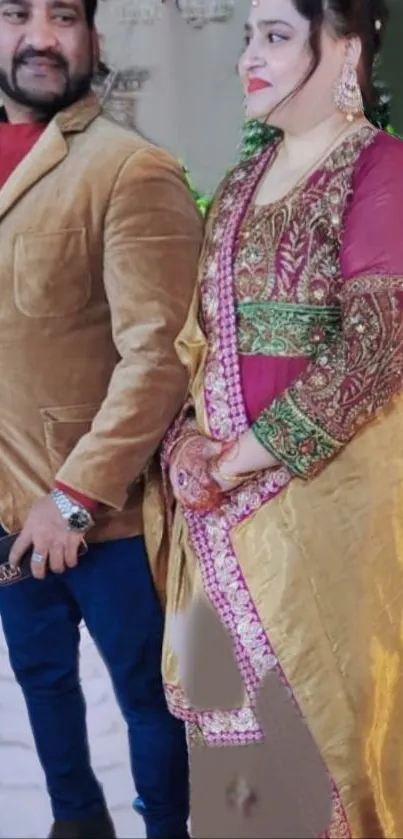 Couple in elegant, traditional outfits with vibrant colors.