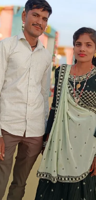 Portrait of a couple in traditional attire with a scenic background.