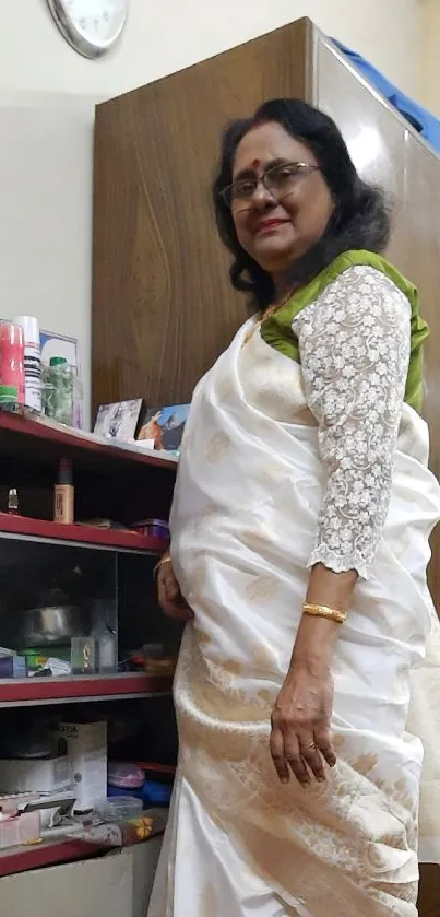 Elegant woman in white saree standing in a room.