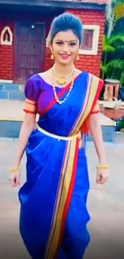 Woman in vibrant blue saree walking gracefully.