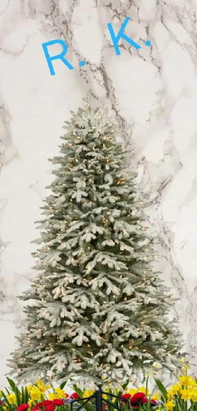 Snow-covered Christmas tree on marble with flowers.