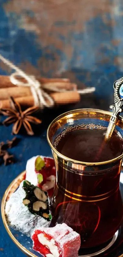 Turkish tea with cinnamon and delight on blue rustic surface.