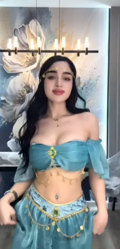 A woman in turquoise attire stands before a floral backdrop.
