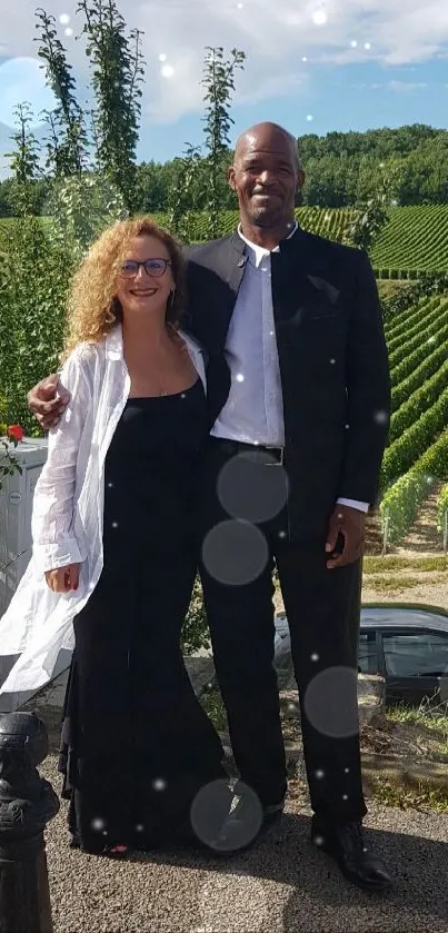 Elegant couple posing in a vineyard landscape.