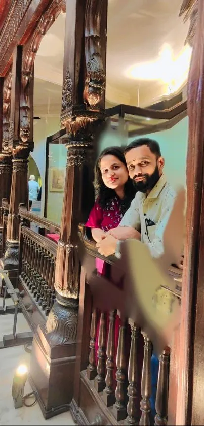 Couple standing in vintage wooden balcony with warm lighting.