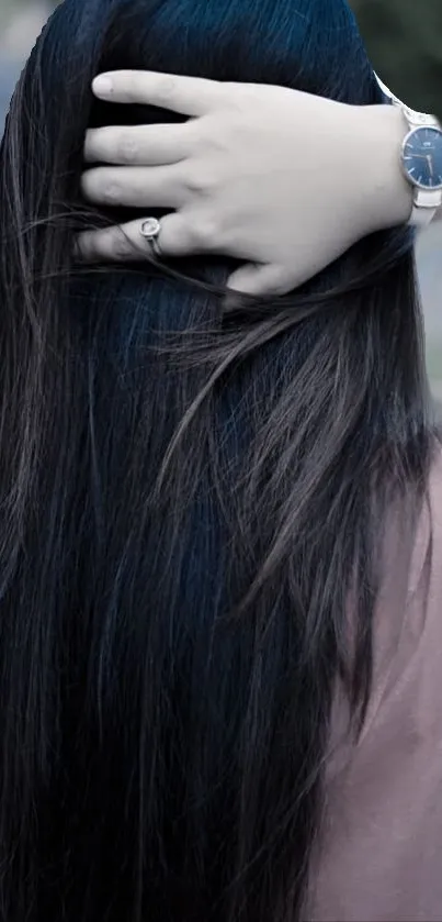 Woman with long black hair wearing a stylish watch.