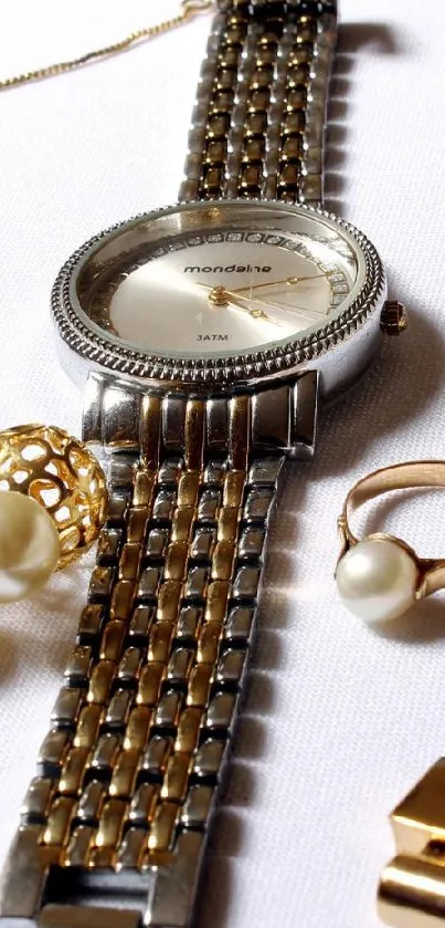 Luxurious display of watch and gold jewelry on white background.
