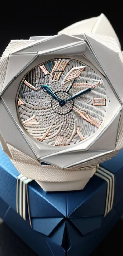 Elegant watch placed on a blue gift box with intricate details.