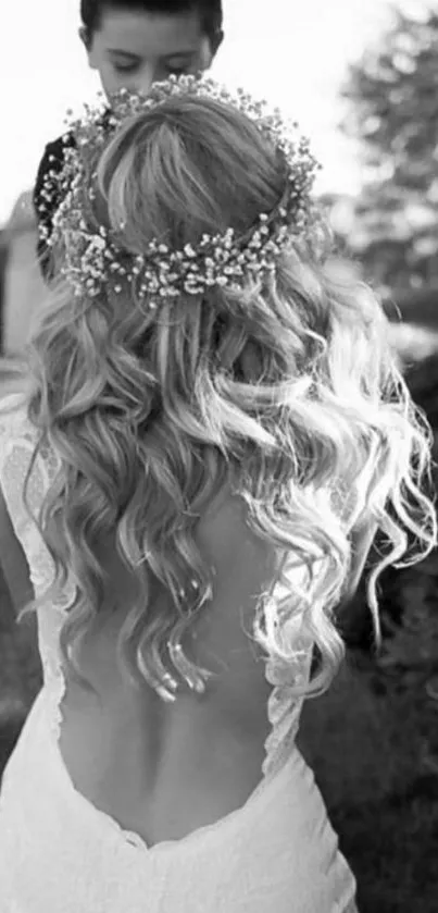 Black and white photo of bride from the back, wearing floral crown.