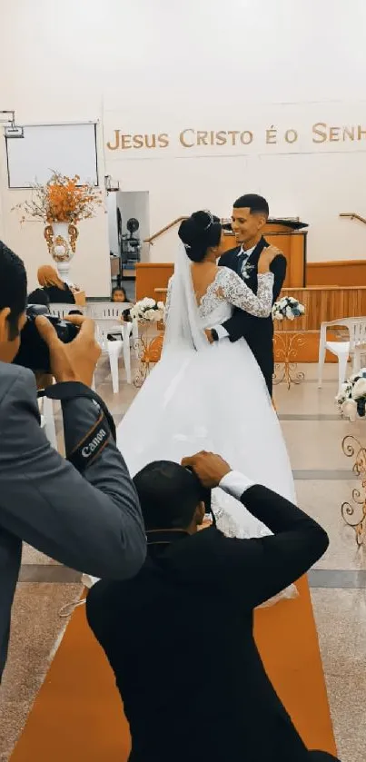 Bride and groom embracing at their elegant wedding ceremony, surrounded by photographers.