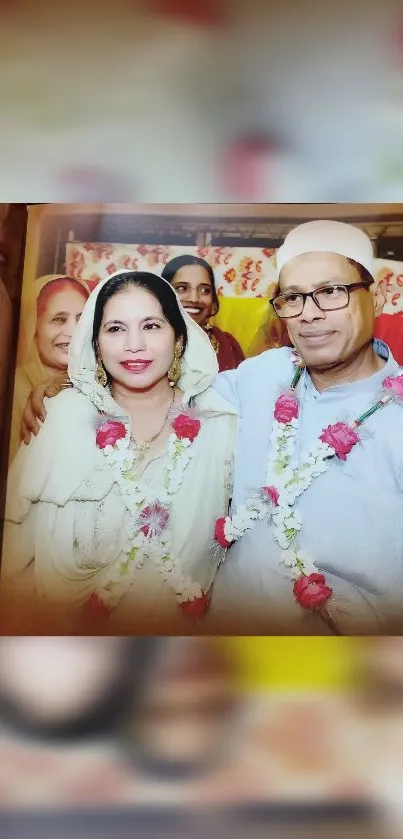 Smiling wedding couple in traditional attire with colorful background.