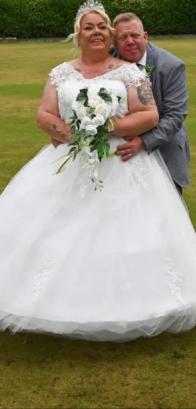 Bride and groom embracing in a green outdoor setting.