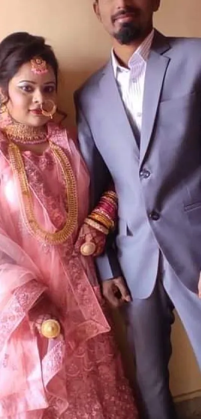 Elegant wedding couple in traditional attire with pink and gray hues.