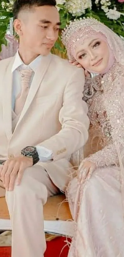 A couple in elegant wedding attire with a floral backdrop.