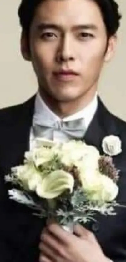 Elegant man in tuxedo with floral bouquet.