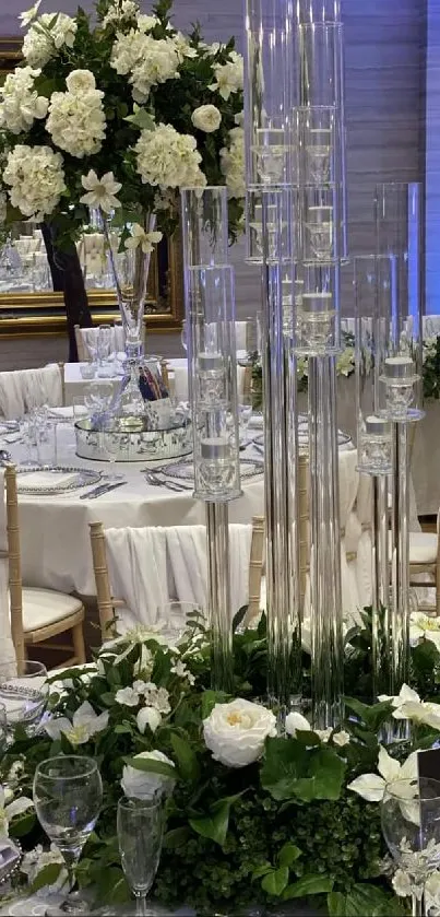 Elegant wedding table setting with white flowers and clear glass centerpieces.