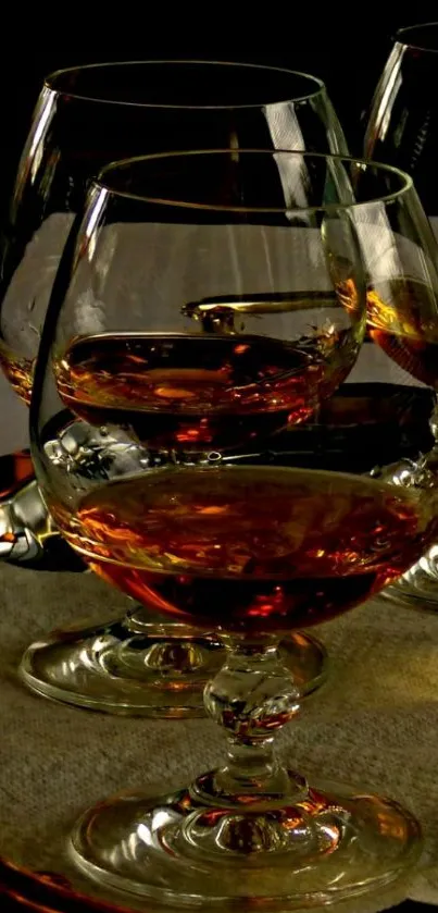 Elegant whiskey glasses with amber liquid on a mobile wallpaper.