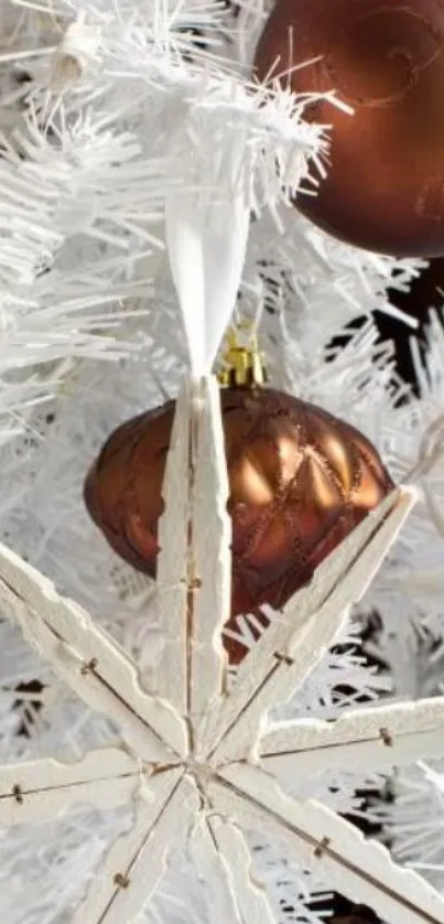 White Christmas tree with bronze ornaments and star decoration.