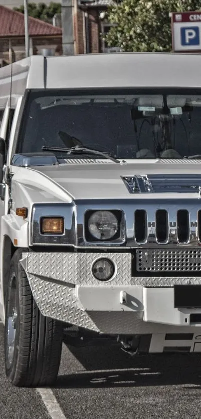 White Hummer limousine parked on a road, showcasing its luxury design.