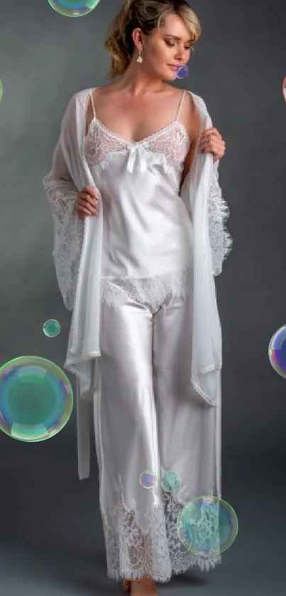 Model in elegant white nightwear against a gray background.