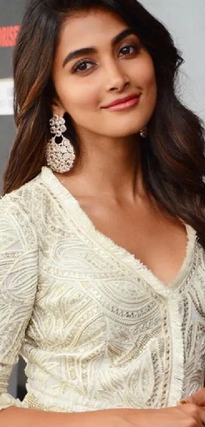 Elegant woman in a white embroidered outfit with earrings.