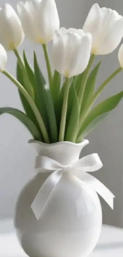 Elegant white tulips in a ceramic vase with a bow.