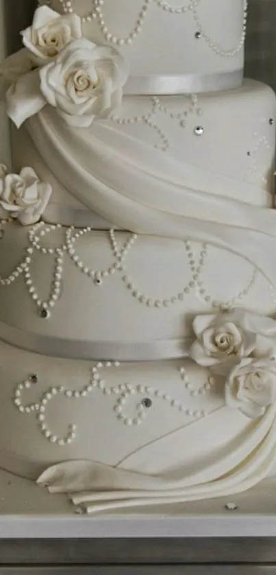 Three-tiered elegant white wedding cake with roses and pearls.