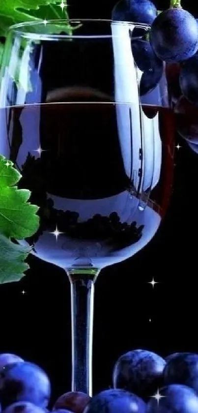 Glass of red wine with grapes and green leaves background.