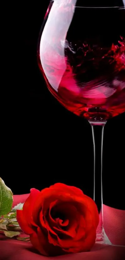 Red wine glass and rose on black background.