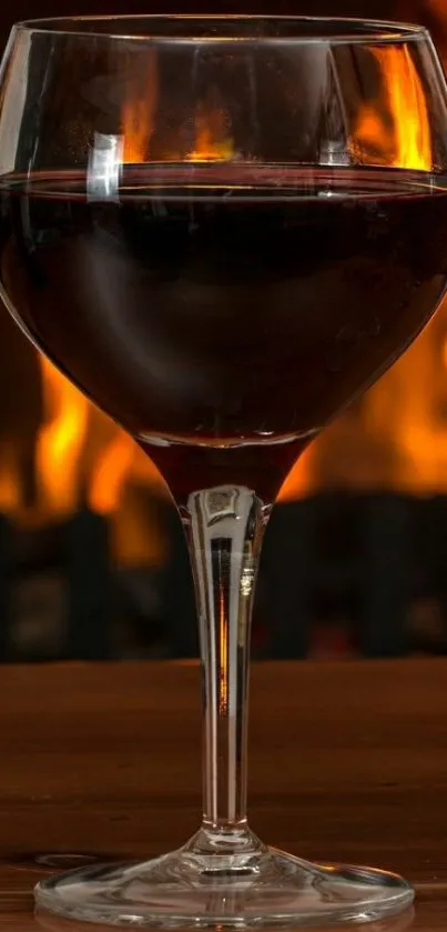 Wine glass in front of a warm fire background.