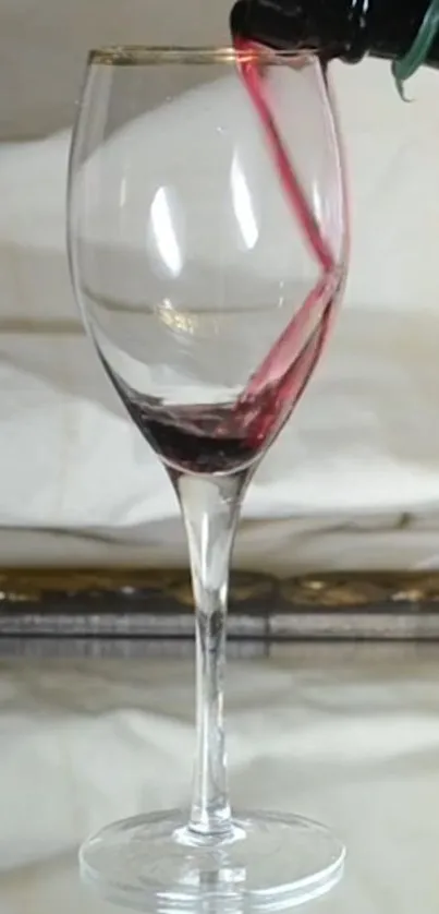 Mobile wallpaper of a wine glass being filled with red wine.