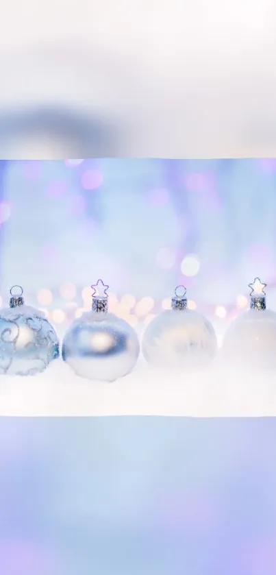 Light blue and silver holiday ornaments in snow with purple lights.