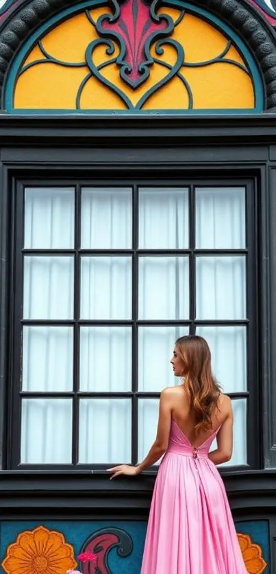 Woman in pink dress standing by a colorful window.