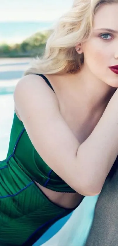 Blonde woman in green dress by a poolside.