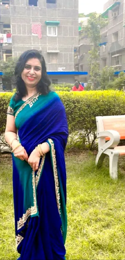 Woman in a blue sari in an outdoor garden setting