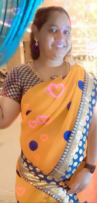 Woman in orange saree with blue dots and glowing hearts background.