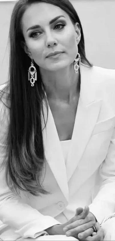 Monochrome portrait of a stylish woman in a classic white suit sitting elegantly.